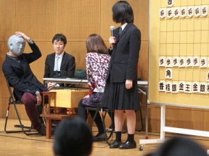 写真左の謎のマスクマンの正体は牧野四段。高浜３級と「王手将棋」を指しました。